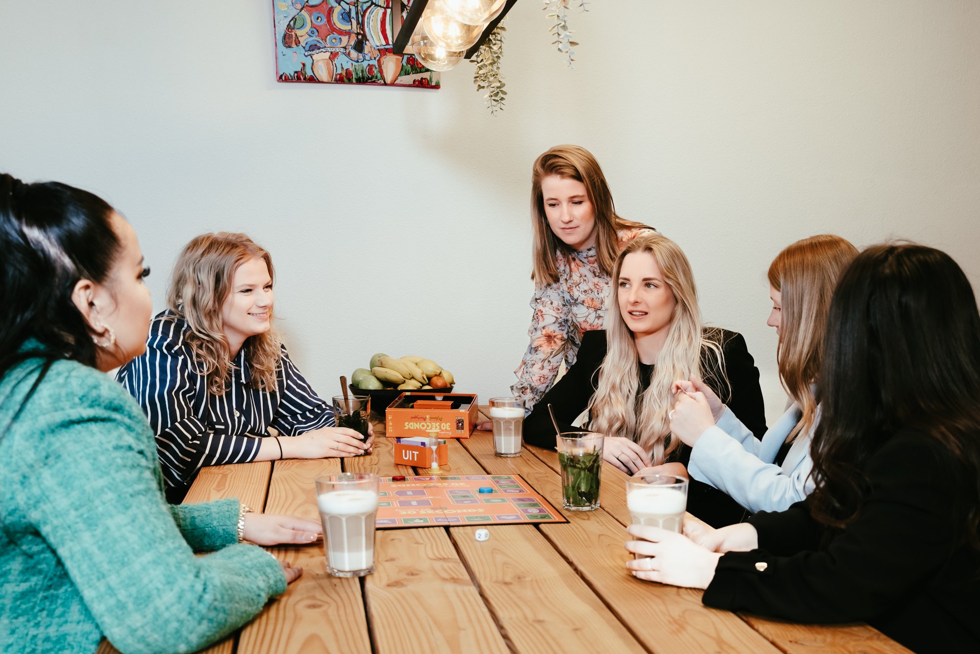 Een groep blije Hello Professionals medewerkers die aan het overleggen zijn